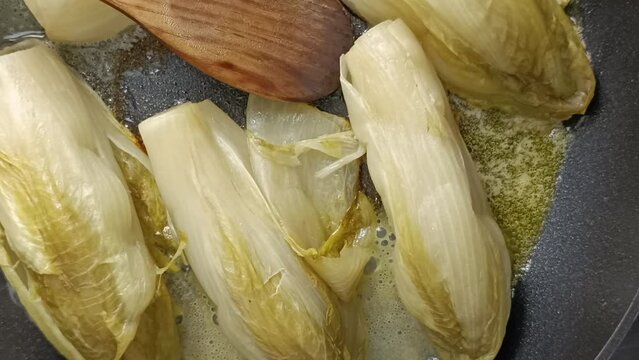 endives en train de cuire dans une po&ecirc;le, en gros plan