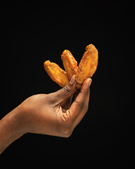 Hand holding 3 chicken wings