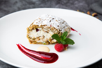 sweet sponge dessert with raspberries and powdered sugar side view