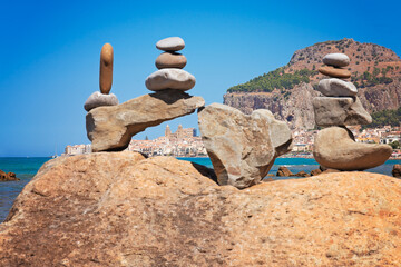 Cefalu Cathedral is framed with cairns (stacked stones) on the beach. The frame is triangle-shaped like Sicily. 