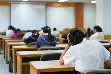 Selective focus high school or university students concentrate on language listening test in the examination hall