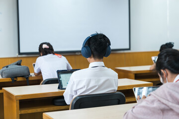 Selective focus high school or university students concentrate on language listening test in the examination hall
