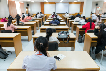 Selective focus high school or university students concentrate on language listening test in the examination hall - obrazy, fototapety, plakaty