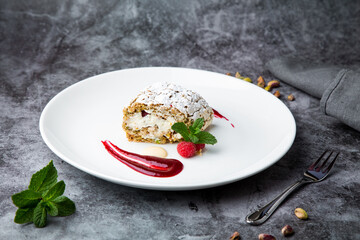 sweet sponge dessert with raspberries and powdered sugar side view