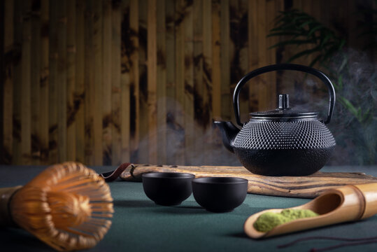 Hot matcha tea in asian iron teapot