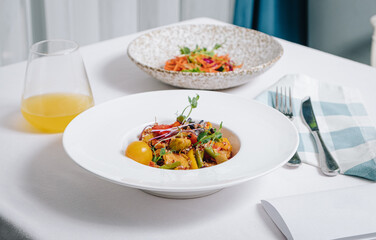 vegetable stew with potatoes, tomatoes and herbs with sauce in a deep plate side view