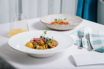 vegetable stew with potatoes, tomatoes and herbs with sauce in a deep plate side view