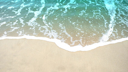 Fototapeta na wymiar Soft blue ocean wave on clean sandy beach