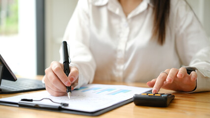 Closeup of female accountant or banker making calculations. Savings, finances and economy concept