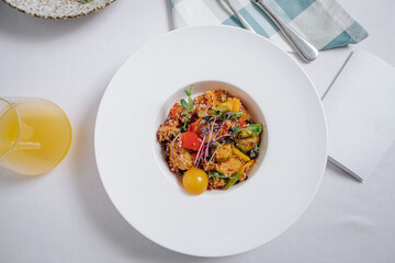 vegetable stew with potatoes, tomatoes and herbs with sauce in a deep plate top view