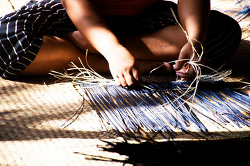 Thai craftsmanship technician and professional local artisan knitting wicker unique handmade krachut or sedge products for show and sale in crafts studio workshop at Thale Noi in Phatthalung, Thailand - obrazy, fototapety, plakaty