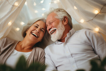 senior couple laughing together in bed, fun and joy, old man grandpa and old woman grandma or mature man and mature woman with gray hair