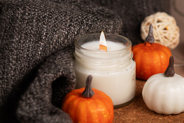 Fototapeta na wymiar candle and warm blanket, autumn decorations with pumpkins