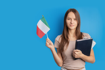 student with italian flag on blue background, language learning, immigration, foreign education, work abroad, copy space