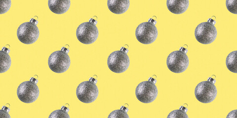 Silver shiny Christmas baubles isolated yellow background New year decorations Glitter ball Minimal composition seamless photo pattern Winter holiday concept Front view flat lay Xmas template Festive