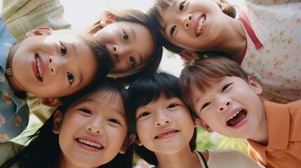 Happy little kids, all smiles, play together in a heartwarming group portrait, as they huddle and look down at the camera..