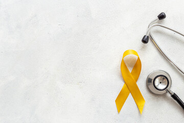 Yellow ribbon symbol of bone cancer and suicide problems awareness concept