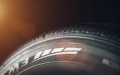 Closeup of the tread of a summer car tire on a sunny day. tires against black. fuel efficient car tires.