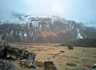 Panoramic landscape view of beautiful snowcapped Himalayas with frozen waterfalls on a foggy winter day. They are famous for tourism in Sikkim, India