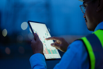 Electrical engineer using laptop computer standing at power station watching power generation planning work at high voltage pole, electrical engineer power station
