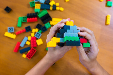 The child is excited. Playing with colored blocks at home, children play and create shapes according to their imagination. develop creativity Develop children's small muscles