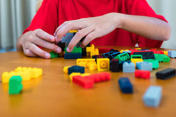 Child playing with colored blocks at home Children play and create shapes according to their imagination, develop creativity, develop children's small muscles.