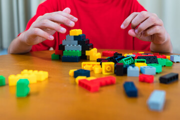 The child is excited. Playing with colored blocks at home, children play and create shapes according to their imagination. develop creativity Develop children's small muscles