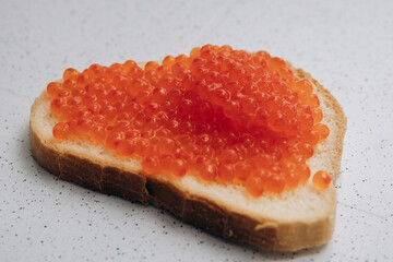 A sandwich with red caviar lies on the table. Healthy eating for weight loss bread and salmon caviar