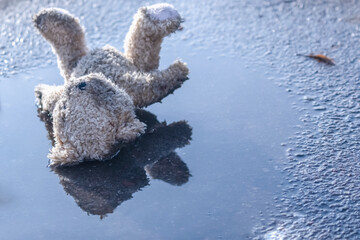 Conceptual image: lost childhood, loneliness, pain and depression. Close up dirty toy Teddy bear...