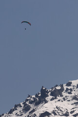 Paraglider Over Snowy Mountain Ridge