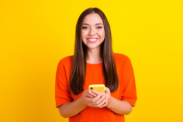 Portrait of attractive lady holding in hands cell playing game free time isolated over bright vivid shine background