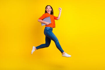 Fototapeta na wymiar Full body photo of stylish trendy girl jump hold laptop isolated on yellow color background