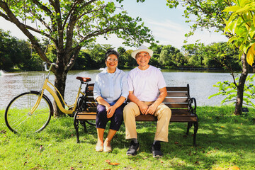 Portrait retired asian senior couple good mental health good mood ้healthy couple cheerful healthy garden outdoor garden where the air is clear and shady pure looking at camera smiling happily.