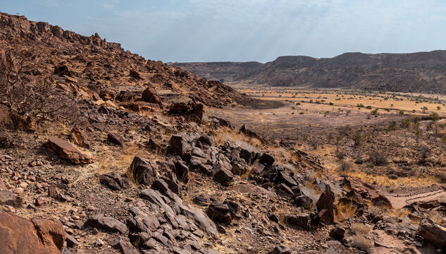 A view down rock strewn slopes across the river valley at Twyfelfontein in Namibia during the dry season
