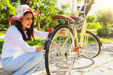 Asian woman wearing hat and her bicycle eco garden botanical garden with lush green trees and shady...