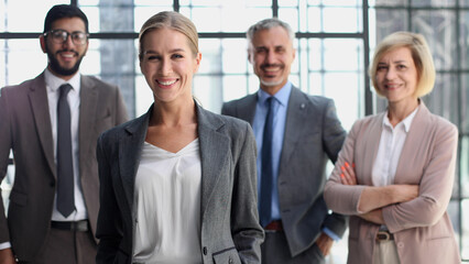business woman with crossed arms against the background of a business team