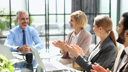 Casual business people around conference table in office