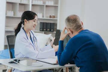 Professional female doctor smiles and shows positive test results to elderly male patient at doctor's appointment in modern office of medical institution