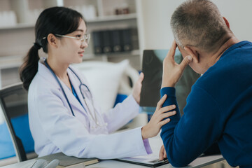 Obraz premium Professional female doctor smiles and shows positive test results to elderly male patient at doctor's appointment in modern office of medical institution