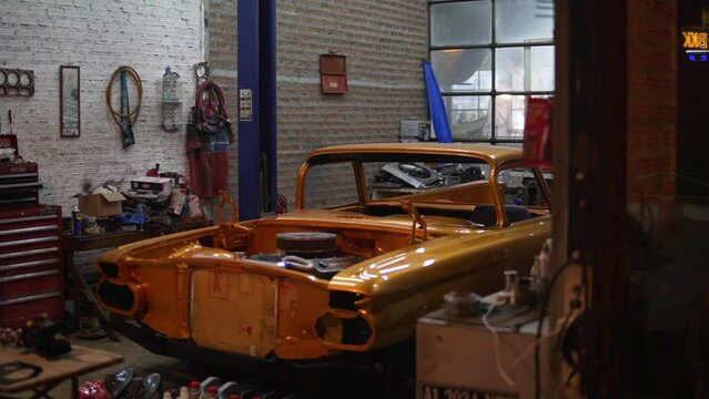 Vintage Auto Body Shop Restoring And Rebuiling An Old Antique Car; Ascending Shot.