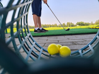Golfer child on practice mat during golf lesson