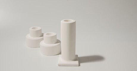 White ceramic candles stand on white background