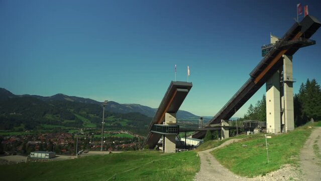 World famous Ski Jump Arena in Oberstdorf Germany. Skiflugschanze Bayern. View of ski jumping hill Audi Arena, part of famous Four Hills Tournament, on sunny day in summer with Allgau mountains. 