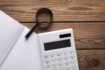 Notebook with magnifiers and calculator on a wooden table
