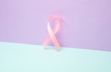 Pink breast cancer awareness ribbon on pastel background