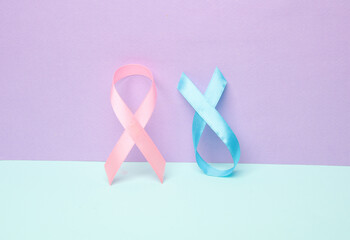 Pink breast cancer awareness ribbon and blue prostate cancer awareness ribbon on pastel background