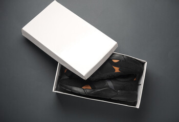 New running shoes in a box on a dark gray background. Top view