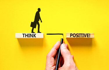 Think positive symbol. Concept words Think positive on beautiful wooden block. Beautiful yellow table background. Businessman hand. Business, motivational think positive thinking concept. Copy space.