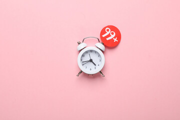 Alarm clock with message notification icon on pink background