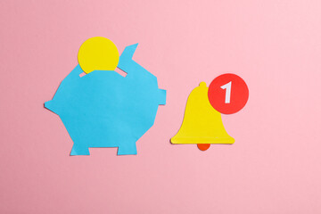 Paper cut piggy bank with notification bell icon on pink background